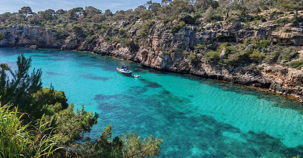 Descubre las impresionantes aguas turquesas y los escarpados acantilados de una pintoresca cala en España.