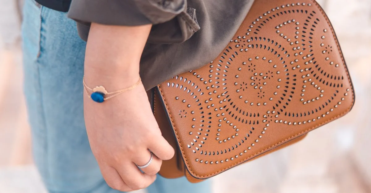 Primer plano de una bolsa de mano artesanal y elegante con una pulsera detallada, que refleja la elegancia y la moda marroquí.