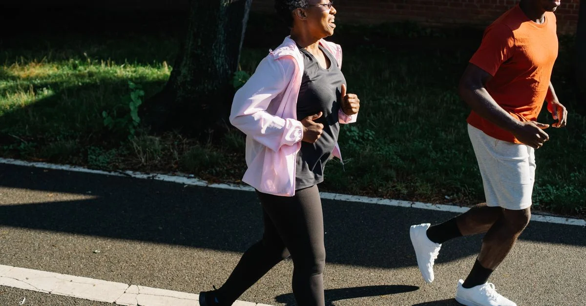 Una imagen dinámica de una pareja corriendo en un día soleado, promoviendo un estilo de vida saludable y fitness.