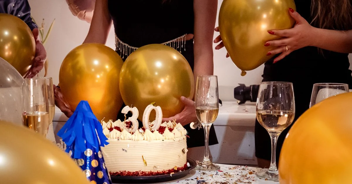 Fiesta alegre del 30 cumpleaños con globos dorados, pastel y bebidas festivas.