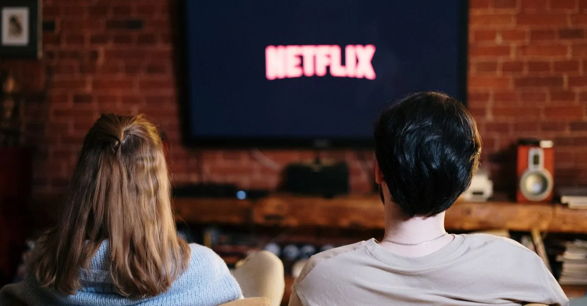 Una pareja disfruta de una noche relajada viendo Netflix en su sala de estar.