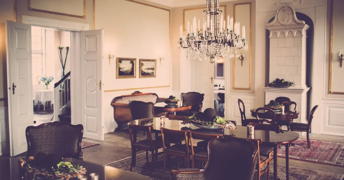 Un comedor de estilo vintage que muestra una gran lámpara de araña y un diseño clásico de muebles.