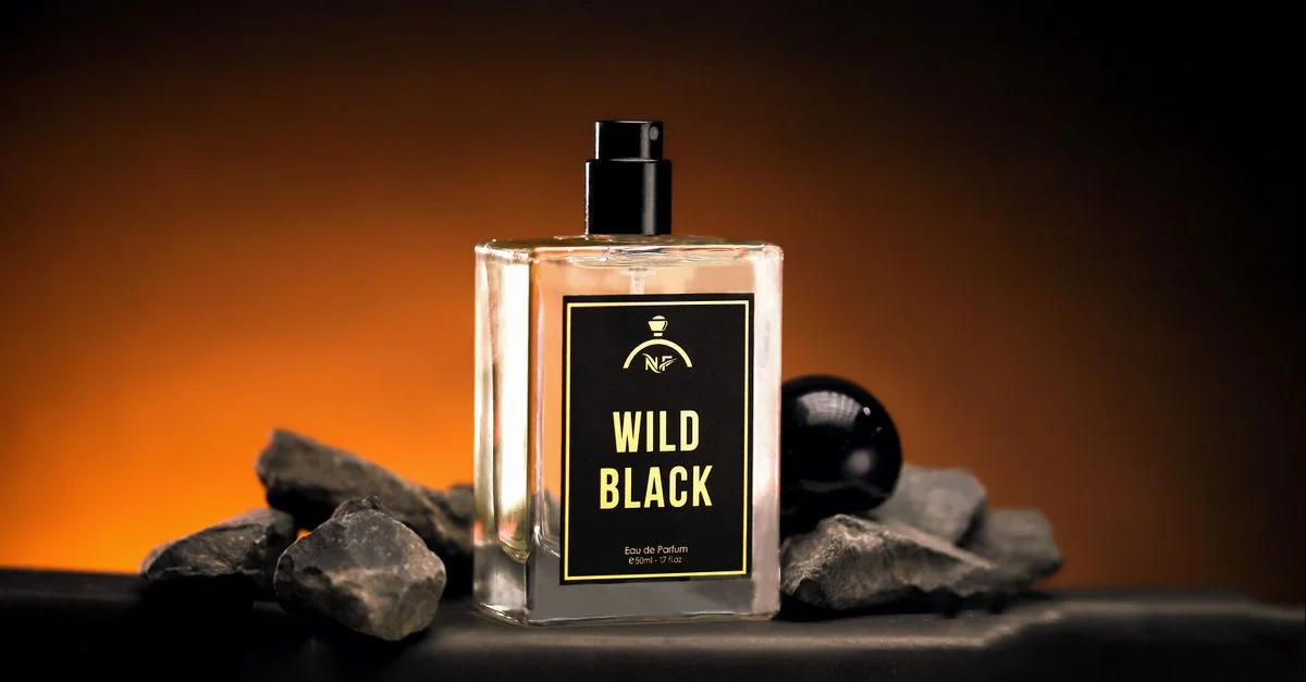 Botella de perfume Negro Salvaje lujosa con iluminación audaz y dramática sobre rocas.
