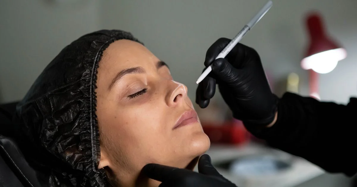 El esteticista aplica un tratamiento facial a la mujer con precisión para realzar su belleza.