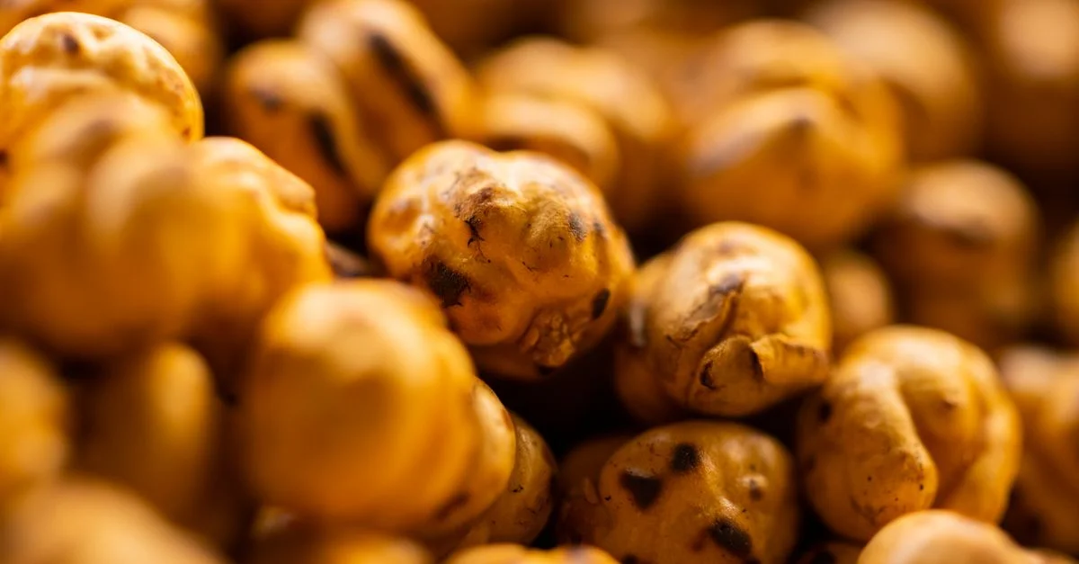 Toma macro de garbanzos tostados que muestra textura y tonos cálidos.