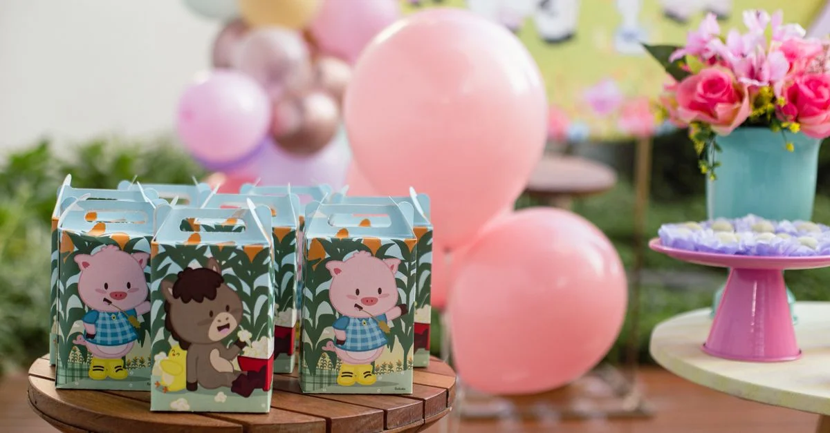 Ambientación vibrante de fiesta de cumpleaños con globos, cajas de regalos y flores.