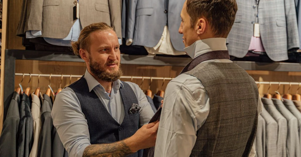 El sastre asiste al cliente en la tienda de ropa con la prueba del traje. Vestimenta profesional y servicio de sastrería.