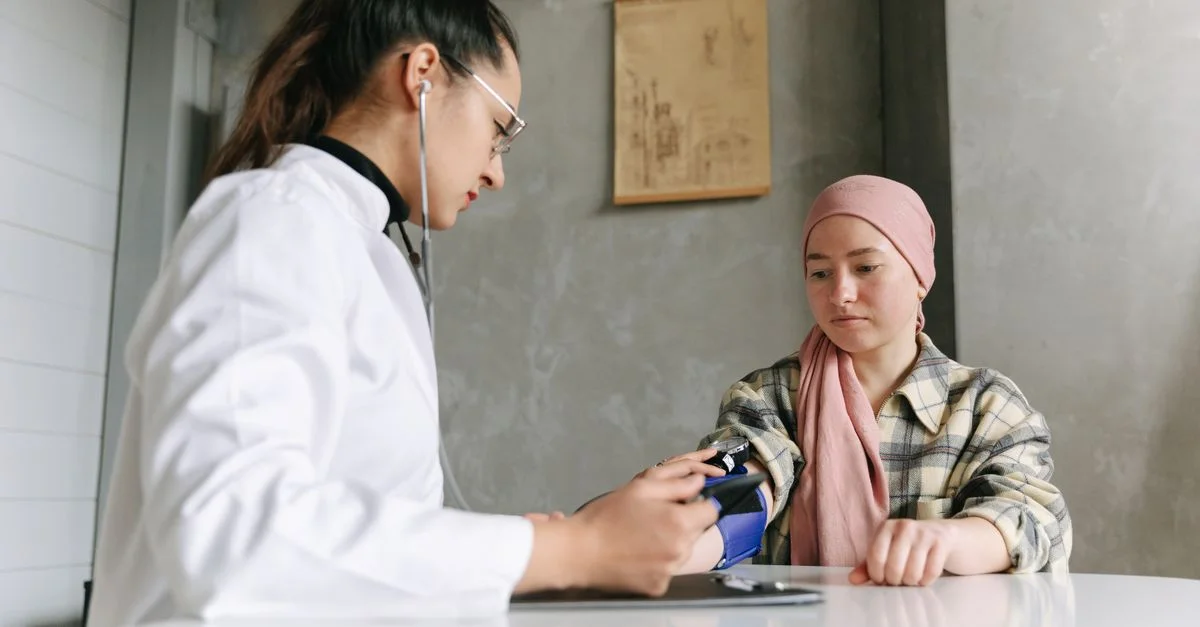 Un profesional médico verifica la presión arterial de una paciente, representando un entorno de atención médica compasiva.