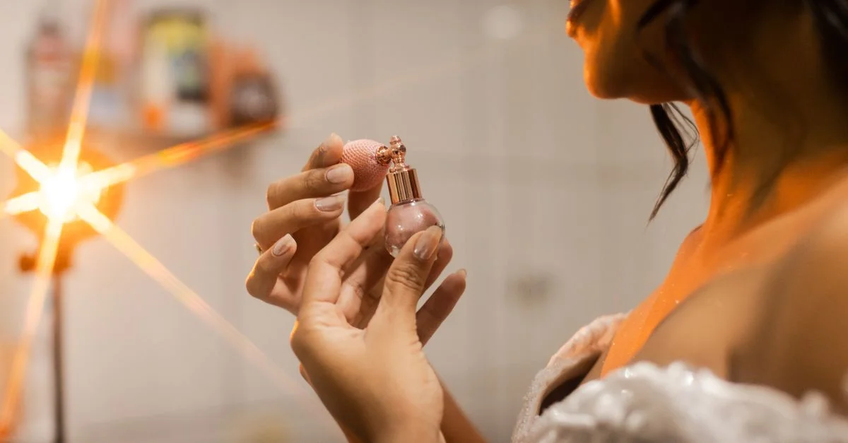 Novia elegante aplicando perfume en preparación para su boda al aire libre en São Paulo.