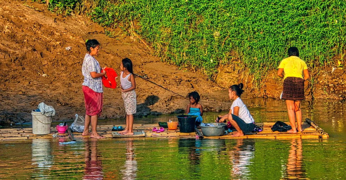 Familia lavando ropa en una balsa de bambú en el río Gunung Sindur, Indonesia.