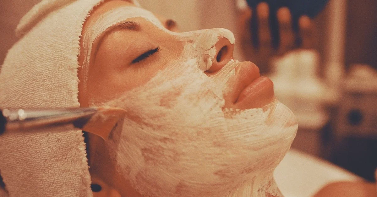 Un relajante tratamiento facial de spa en el que una mujer recibe la aplicación de una lujosa mascarilla facial.