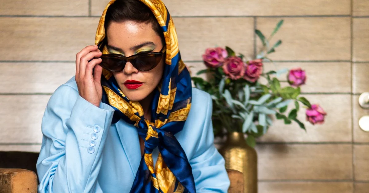 Retrato moderno de una mujer elegante en Ciudad de México vestida con un atuendo azul, gafas de sol y un pañuelo colorido.