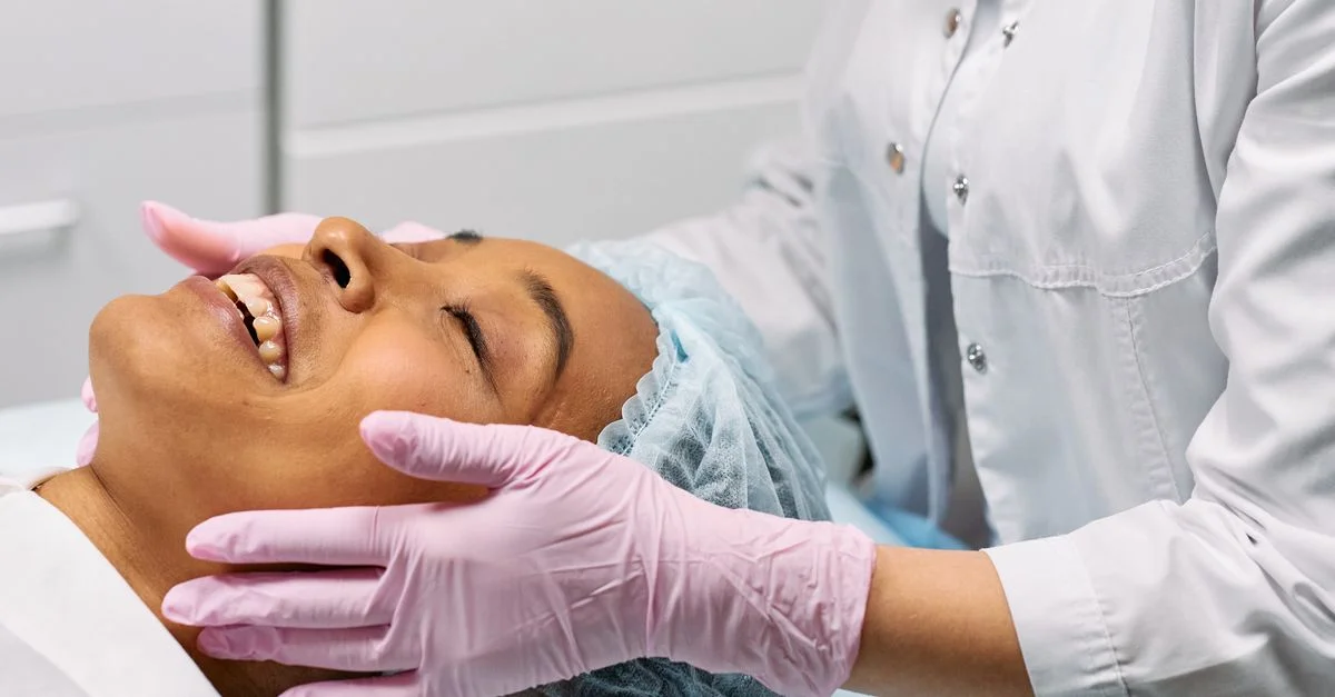 Una clienta recibiendo un tratamiento facial relajante en una clínica de spa moderna.