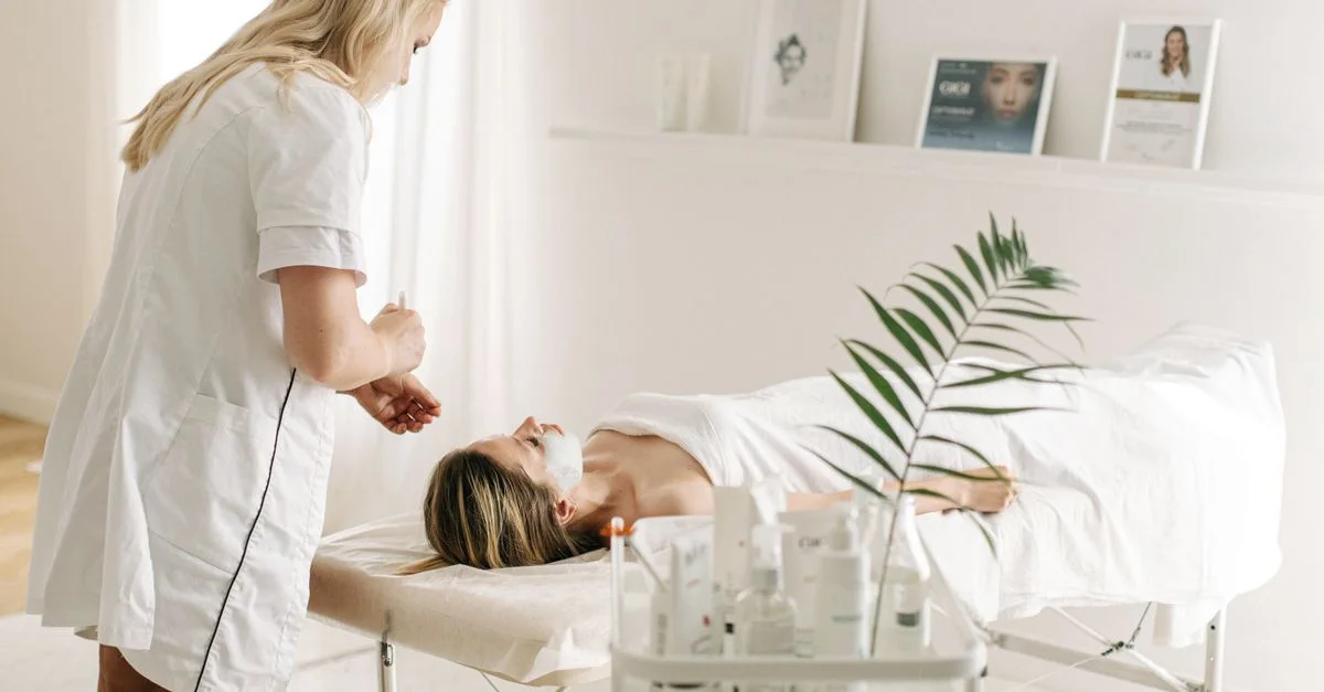 Un entorno de spa sereno que presenta un tratamiento facial con un esteticista profesional, destacando la relajación y el cuidado de la piel.